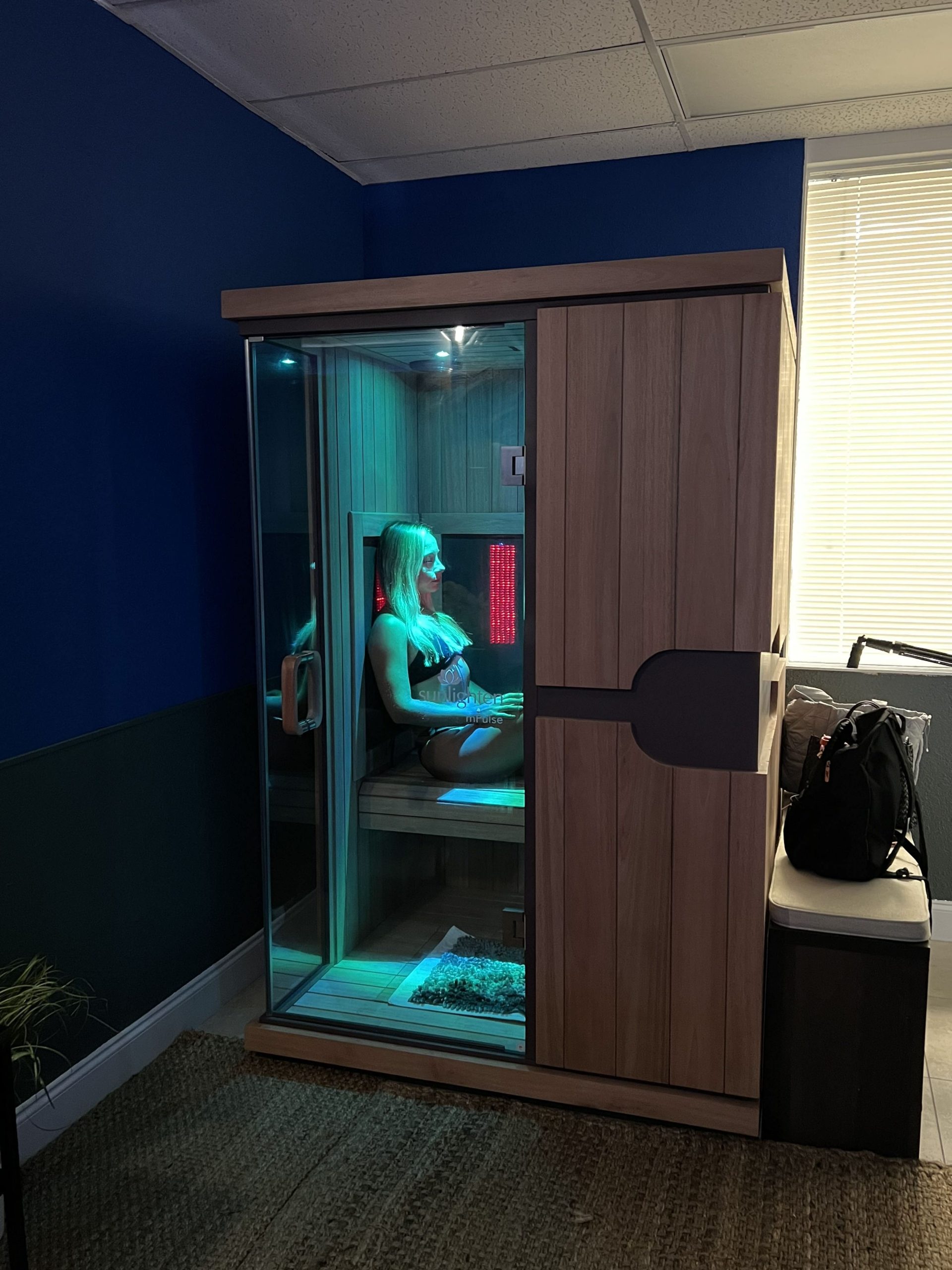 A person sitting in a sauna with lights on.