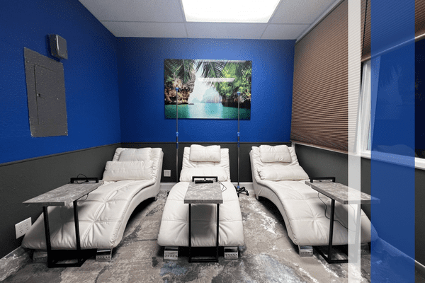 Three white lounge chairs in IV room.